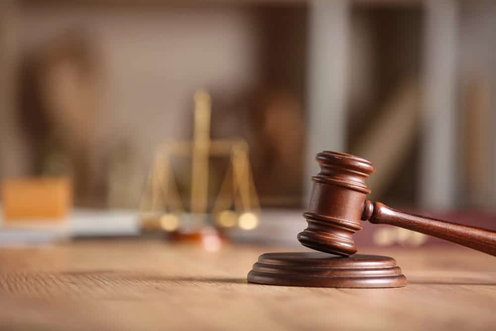 Image is of a courtroom gavel with justice scales in the background, concept of sexual assault in Washington and pursuing legal options.