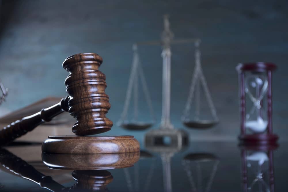Image is of a judge’s gavel beside balanced scales of justice, concept of legal standards and eligibility for a mass tort claim in Louisville.
