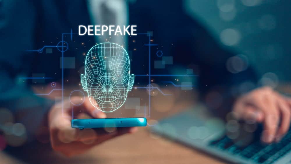 Image is of a smartphone displaying a digital facial scan and the word deepfake, representing the rise of AI-generated nonconsensual images and advancing facial manipulation technology.