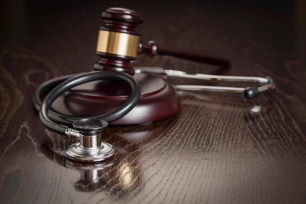 Image is of a judge gavel with a stethoscope on a desk, representing medical claims and mass tort cases in Washington