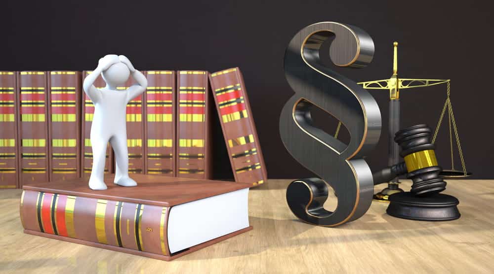 Image is of legal books, gavel, and stressed figure standing on a law book, showing challenges faced by union workers and their workplace protections.