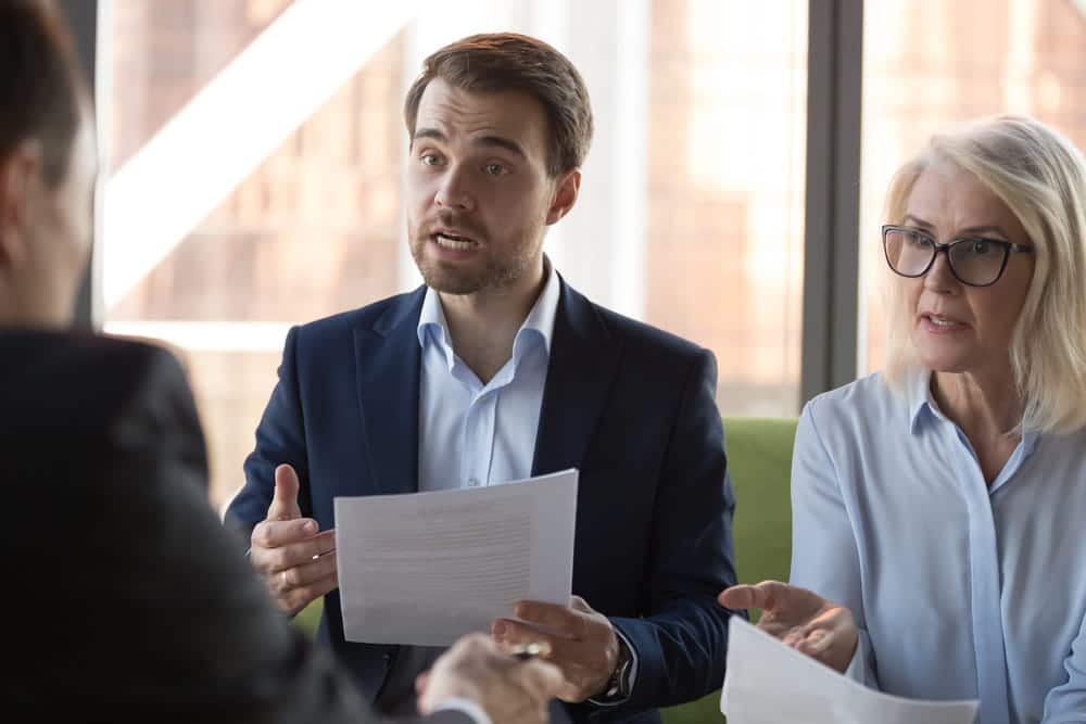 Image is of two individuals discussing a legal matter with a lawyer, concept of civil litigation in Washington