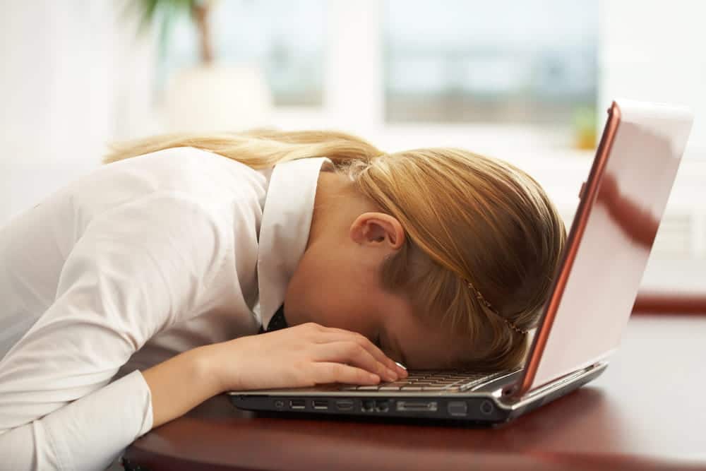 Image is of a stressed individual resting on a laptop showing emotional impact of image abuse in Nashville