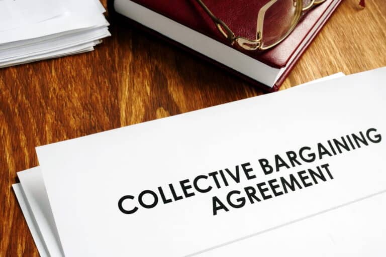 Image is of a printed collective bargaining agreement on a desk, symbolizing collective bargaining rights under Kentucky law.