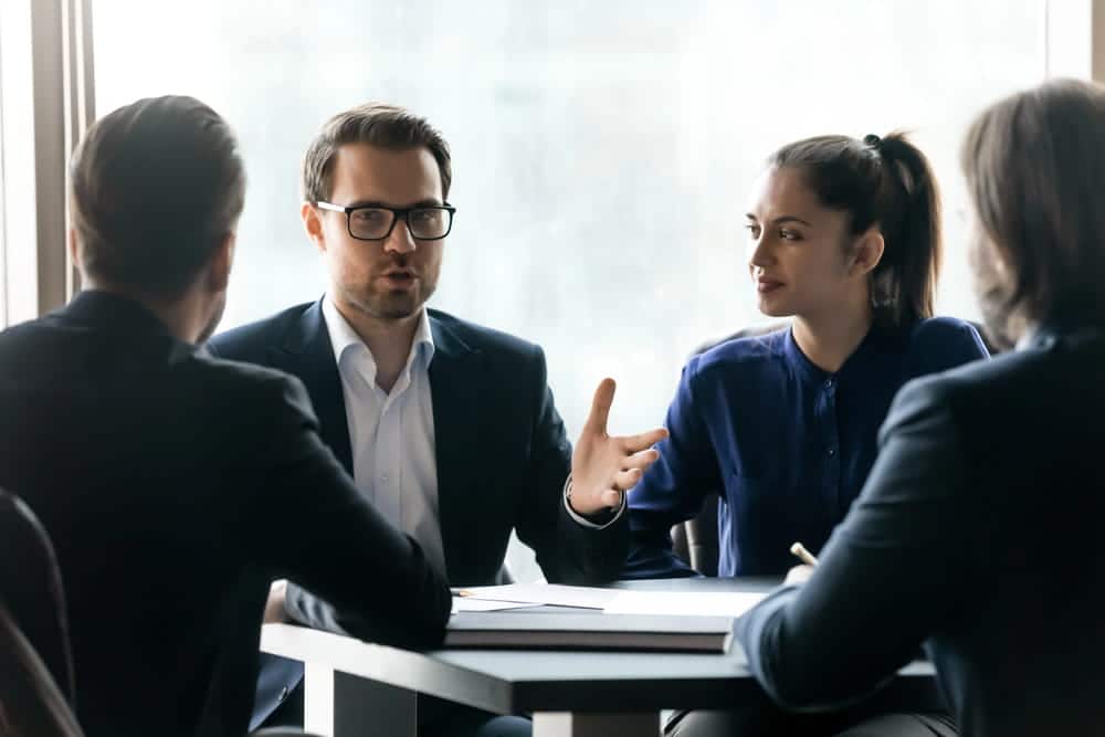 Image is of attorneys discussing workplace negotiation strategy at a conference table, representing collective bargaining under KY law.