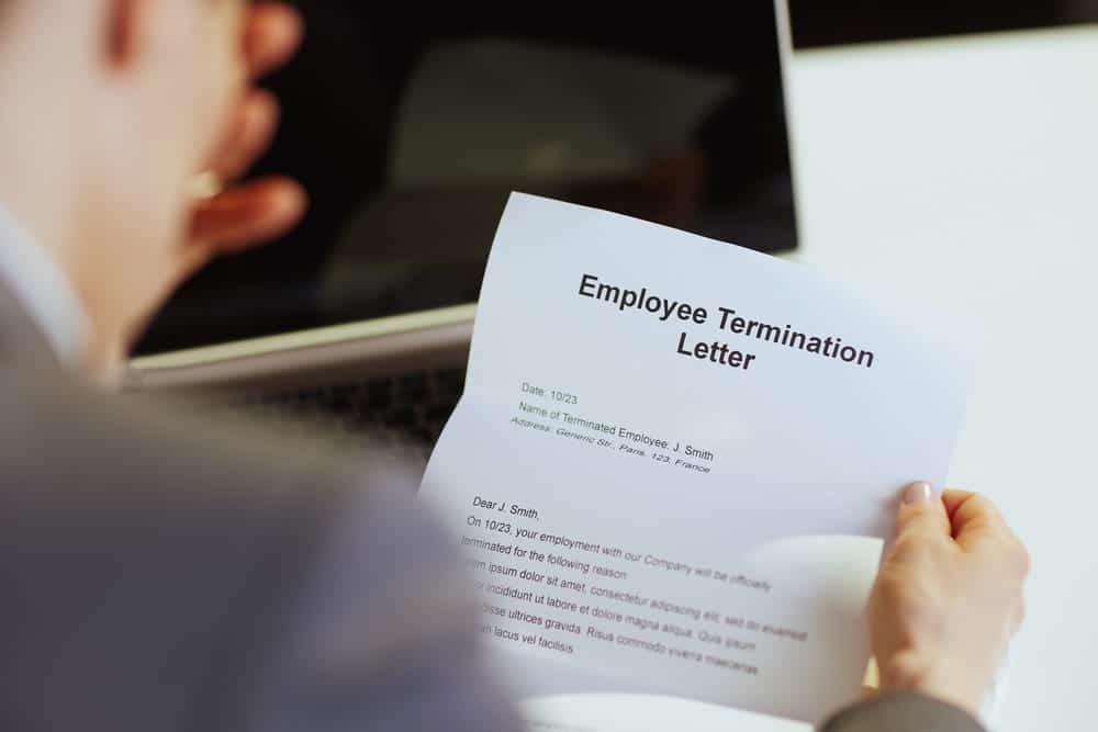 Image is of an employee reviewing a termination notice, concept of labor contract disputes and workplace enforcement issues in Ohio.