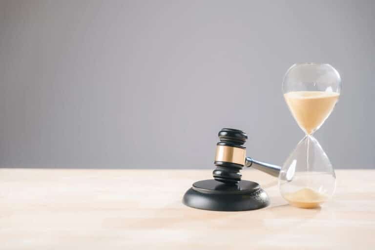 Image is of a judge’s gavel beside an hourglass, concept of legal timelines in mass tort cases