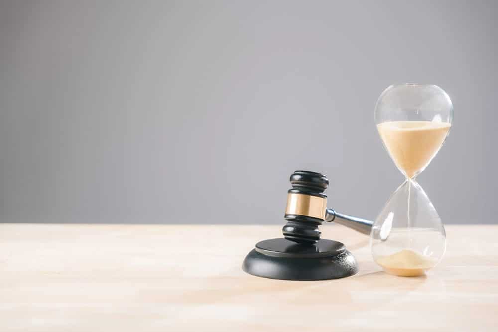 Image is of a judge’s gavel beside an hourglass, concept of legal timelines in mass tort cases