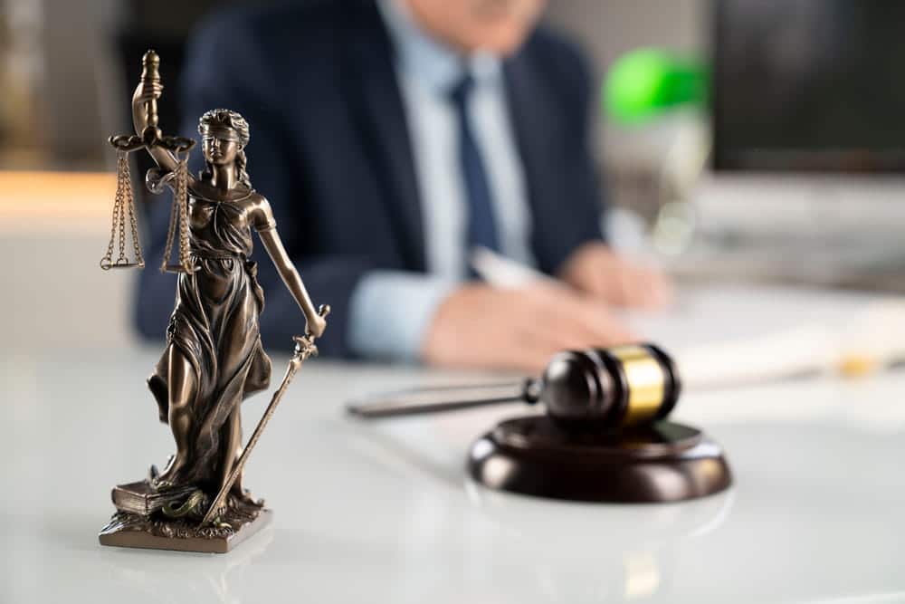 Image is of a Lady Justice statue and gavel inside a law office, concept of mass torts in Cincinnati.
