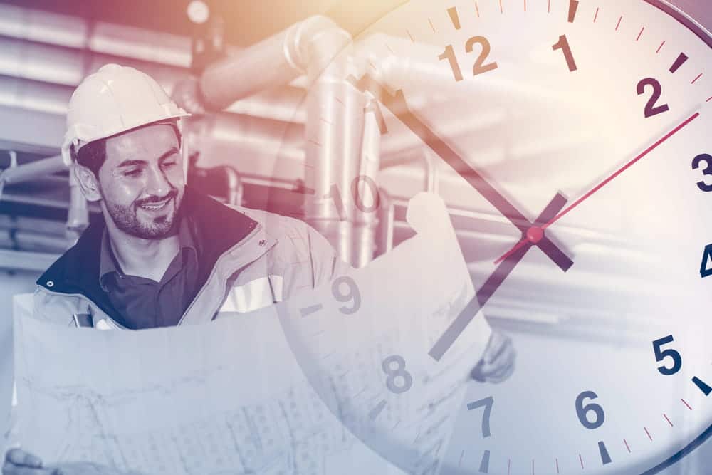 Image is of an industrial worker reviewing plans beside a clock overlay, concept of collective bargaining over scheduling and work hours in Tennessee.