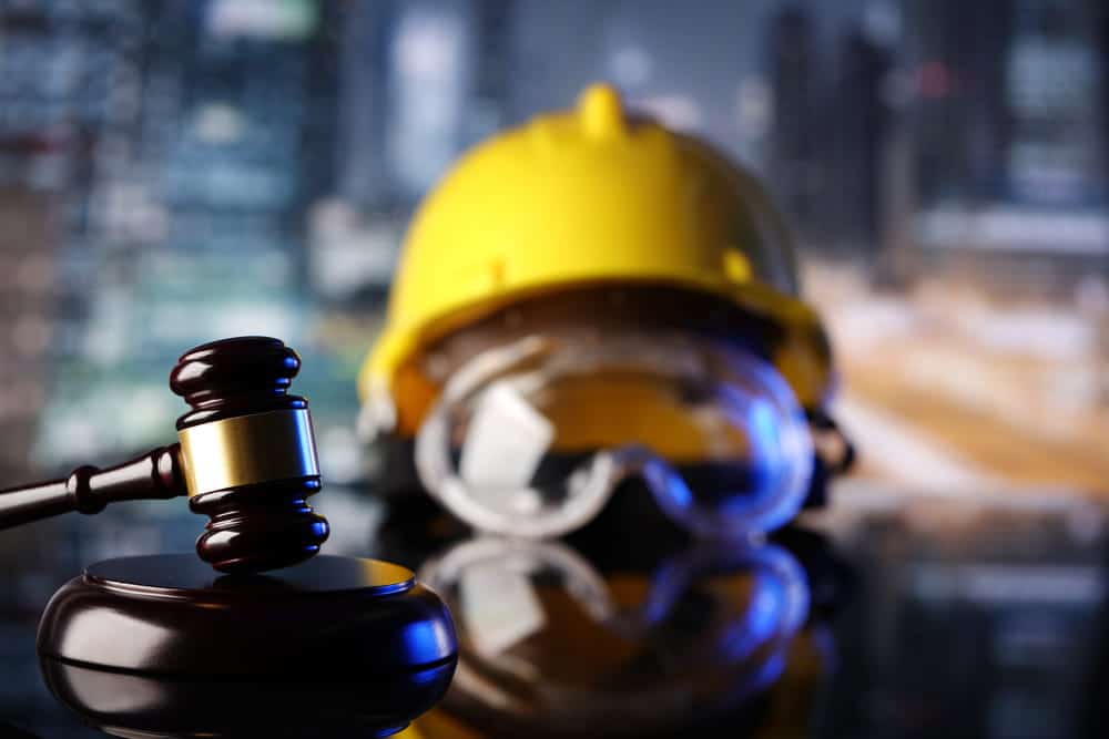 Image is of a business professional speaking on the phone while working late at an office desk, concept of workplace disputes involving labor law in Kentucky.