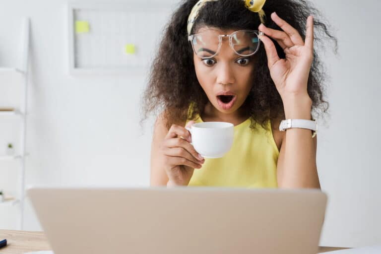 Image is of a person looking surprised while viewing content on a laptop screen, concept of AI image manipulation and its potential legal consequences in Tennessee.