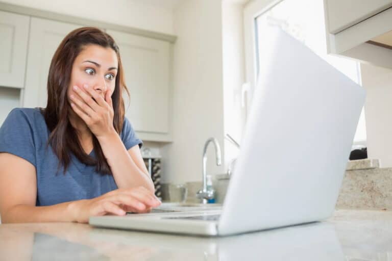Image is of a person looking at a laptop with a shocked expression, representing the emotional impact of AI-altered images on personal rights.