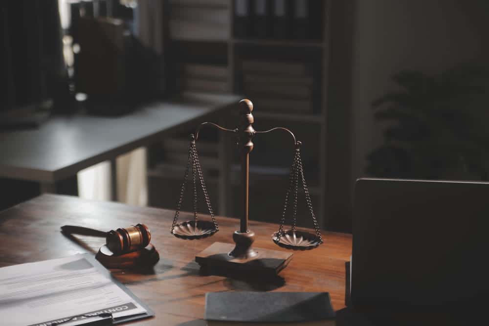 Image is of a gavel and scales of justice on a law office desk, representing the legal process and summary judgment in Washington, D.C.