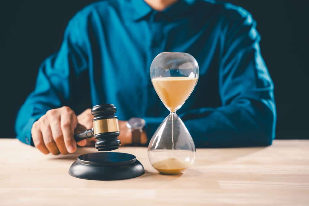Image is of a judge's gavel beside an hourglass on a table, concept of mass tort case