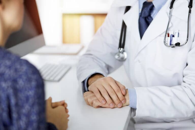 Image is of a doctor consulting with a patient, concept of medical evaluation and evidence for mass torts in Louisville.