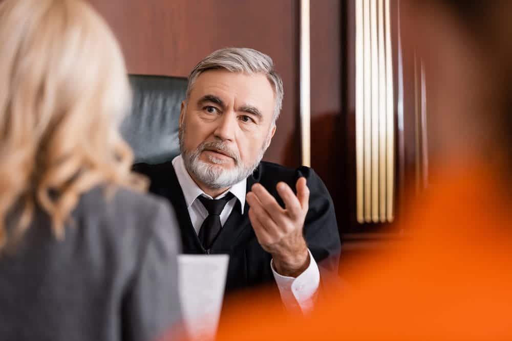 Image is of a judge speaking with a woman in court, representing evidence evaluation in civil litigation.