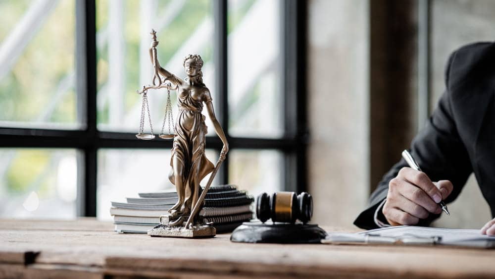 Image is of legal documents beside a gavel and Lady Justice statue, representing evidence in civil litigation.