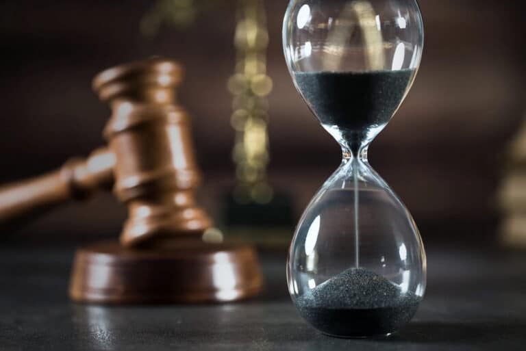 Image is of an hourglass beside a judge’s gavel, concept of how long lawsuits take in Nashville