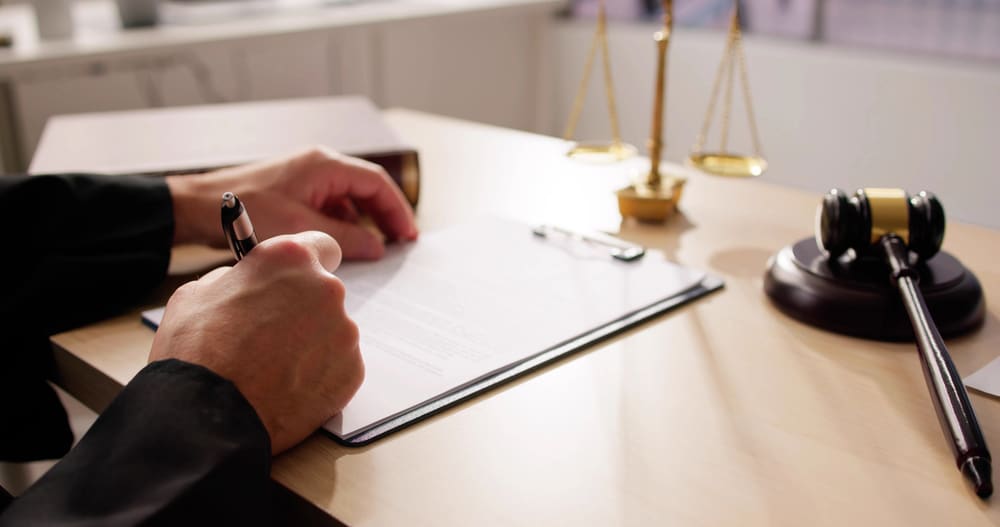 Image is of a lawyer reviewing and signing legal documents, concept of mass tort litigation in Cincinnati, Ohio.