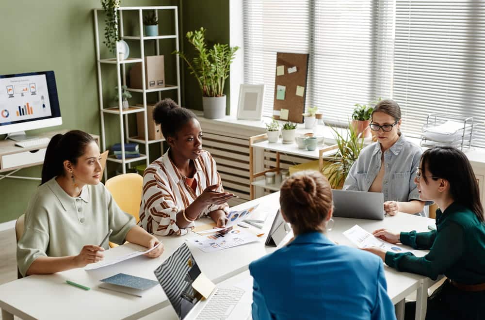 Image is of employees discussing workplace issues together around an office table, concept of fair representation in TN