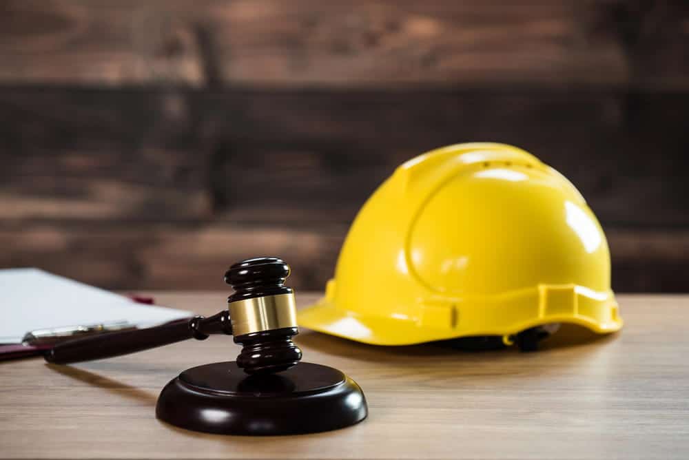 Image is of a judge’s gavel beside a construction hard hat, concept of legal rights for union workers.