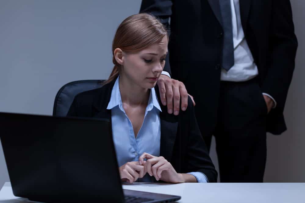 Image is of a man placing his hands on a female employee, concept of sexual assault in Kentucky and institutional liability.